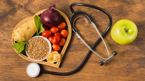 ovocie s fonendoskopom na drevenom podklade symbolizujúce ako znížiť cholesterol