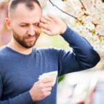 peľová sezóna - muž pri strome ktorého svrbia oči